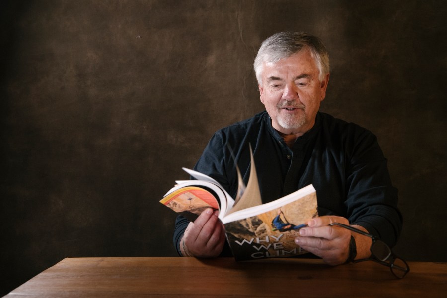 Jim Moss, examining the book "Why We Climb"